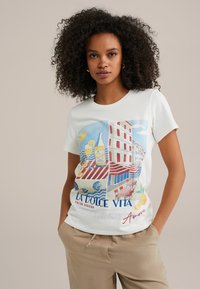 Witte katoenen t-shirt met een kleurrijke grafische print van Italiaanse kustcafés, met rode en blauwe accenten en een ronde halslijn.