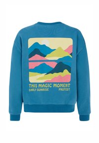 Modrá mikina s grafickým potlačou hôr a slnka v pastelových farbách, s textom "TENTO MAGICKÝ MOMENT RANNÍHO SVITU PROTEST".