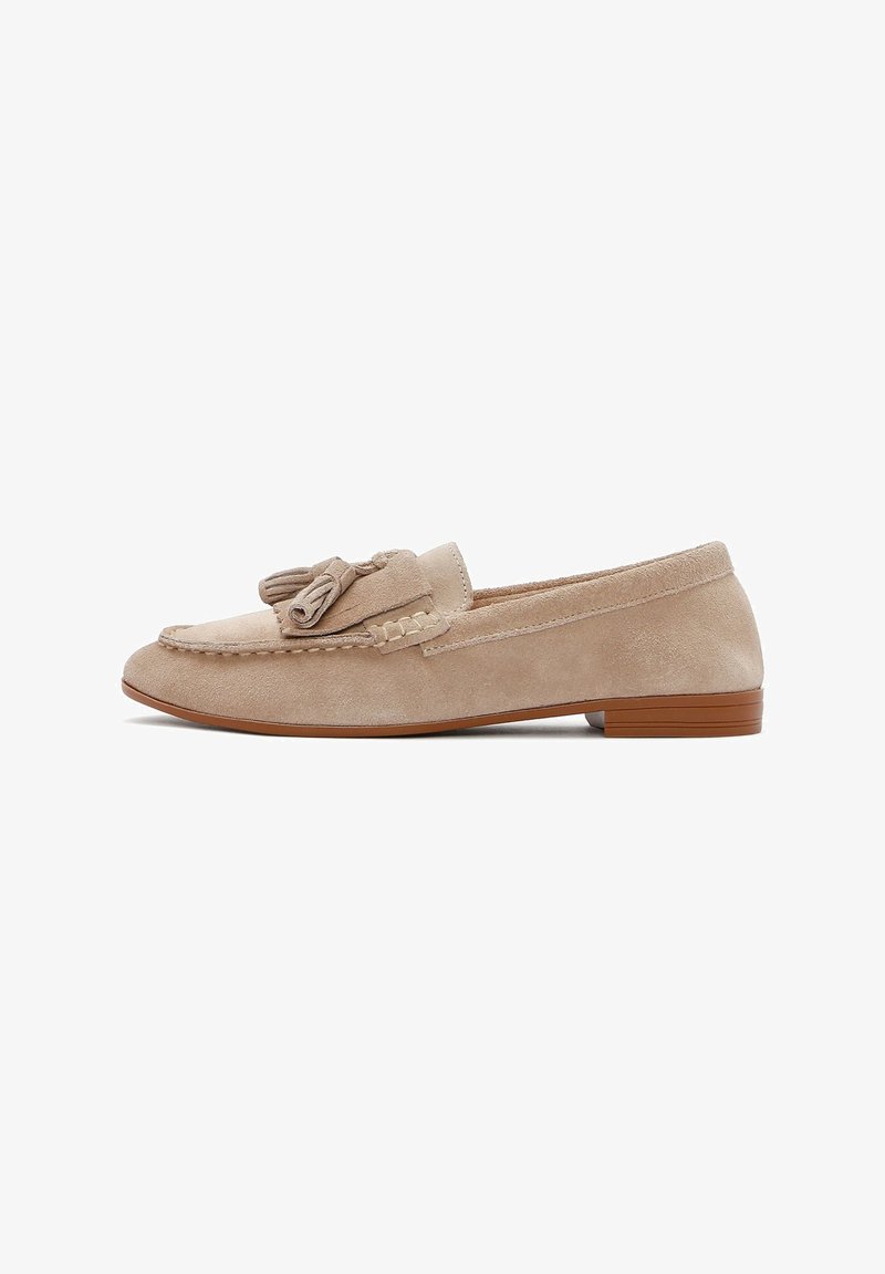 Beige suede loafer with a rounded toe, decorative bow accent, and a low brown sole; smooth texture and simple stitching detail.