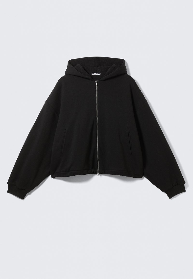 Juodas gobtuvu megztinis su pilnu užtrauktuku, laisvas kirpimas, ilgi rankovės, šoninės kišenės ir ribbintinės rankogaliai. Pagaminta iš minkštos, struktūruotos medžiagos.