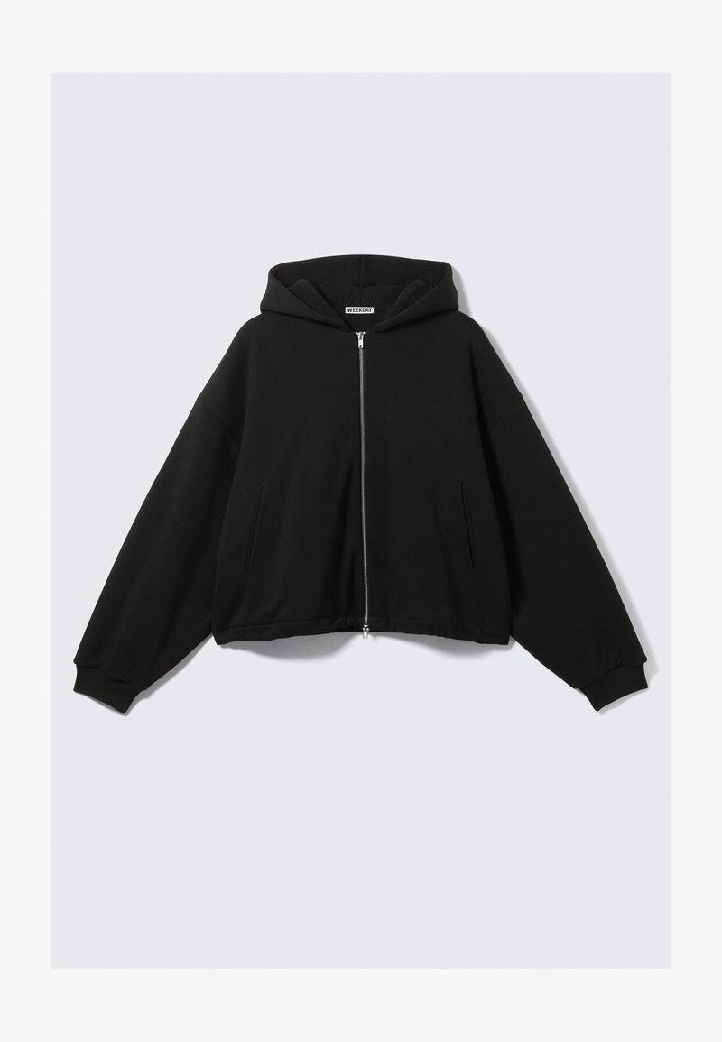 Juodas gobtuvu megztinis su pilnu užtrauktuku, laisvas kirpimas, ilgi rankovės, šoninės kišenės ir ribbintinės rankogaliai. Pagaminta iš minkštos, struktūruotos medžiagos.