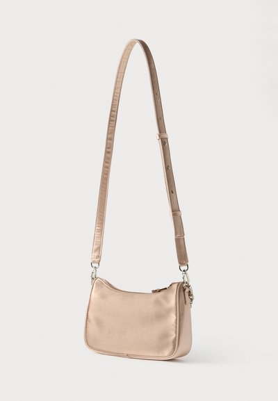 Τσάντα ώμου από σατέν σε απαλό ροζ με στρογγυλεμένο σχήμα, ρυθμιζόμενη τιράντα, ασημένια μεταλλικά στοιχεία και κλείσιμο με φερμουάρ. Ομαλή υφή και λιτός σχεδιασμός.