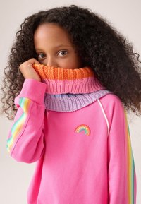 Felpa rosa con colletto a coste multicolore, con strisce arancioni, rosa e viola. Piccolo ricamo arcobaleno sul petto.