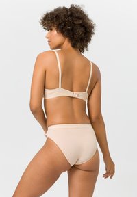 Beiges BH- und Bikini-Set mit verstellbaren Trägern und einem Haken- und Ösenverschluss am Rücken. Glattes, weiches Material mit minimalistischen Details.
