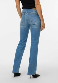 Hele sinine teksariidest suupärased püksid, millel on keskmise kõrgusega vöökoht, neli taskut ja nähtav õmblus. Sile tekstuur peente pleegituse detailidega.