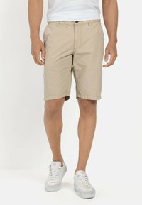 Beige shorts van een lichtgewicht stof, met een knoopsluiting en zijzakken. Draag ze met witte sneakers voor een casual look.