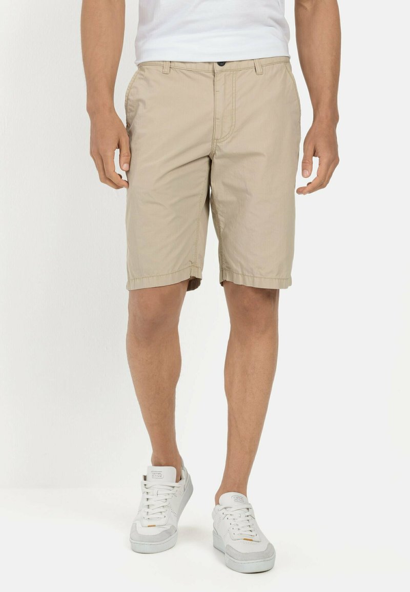 Beige shorts van een lichtgewicht stof, met een knoopsluiting en zijzakken. Draag ze met witte sneakers voor een casual look.
