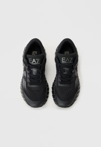 Ζεύγος μαύρων sneakers EA7 Emporio Armani με υφασμάτινες σόλες και σχέδιο με κορδόνια, προφίλ από πάνω σε απλό φόντο.