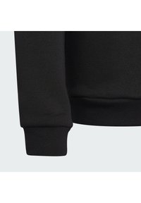 Black sweatshirt with ribbed cuffs and hem, featuring a soft texture. The fabric appears smooth with a slight stretch.