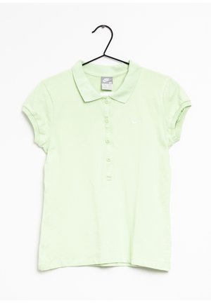 Jasnozielona koszulka polo Nike z krótkimi rękawami, zapinana na guziki, z małym białym logo Swoosh na lewej piersi, wisząca na czarnym wieszaku.