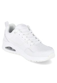 Chaussure de sport blanche avec une tige en cuir lisse, des accents perforés, des lacets, un col rembourré et une unité de coussin d'air visible dans la semelle.