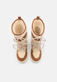 Botas de invierno marrones y crema hechas de piel sintética y ante, con un puño acolchado, cordones texturizados y una suela de goma blanca.