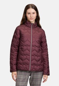 Giacca trapuntata borgogna con colletto alto, motivo di cucitura a forma di cuore, zip frontale e tasche laterali. Materiale leggero.