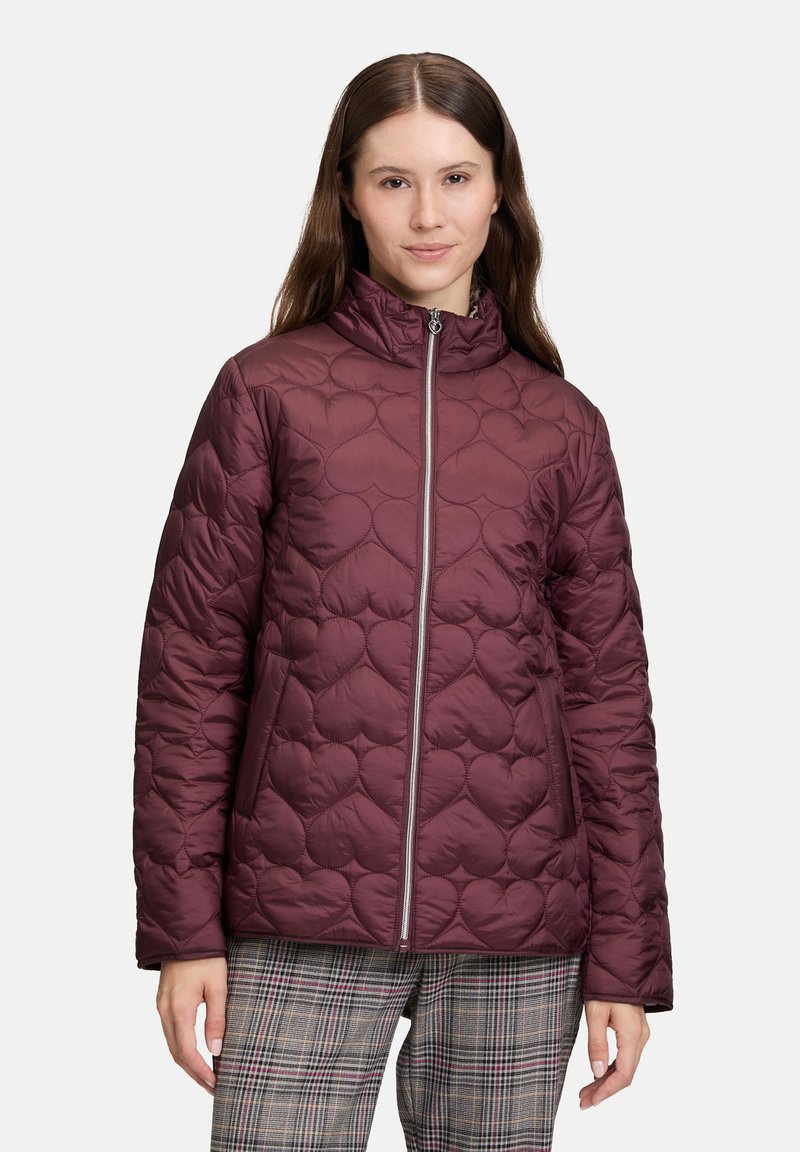 Giacca trapuntata borgogna con colletto alto, motivo di cucitura a forma di cuore, zip frontale e tasche laterali. Materiale leggero.