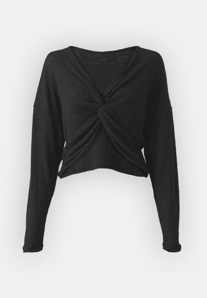 Juodas trumpas ilgomis rankovėmis viršus su sukta priekyje. Pagamintas iš tekstūruoto audinio, su laisvu siluetu ir subtiliu briaunuotu raštu.