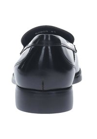 Mocassini in pelle verniciata nera con punta arrotondata, tacco basso e una superficie liscia. Presentano cuciture sottili e dettagli minimi.