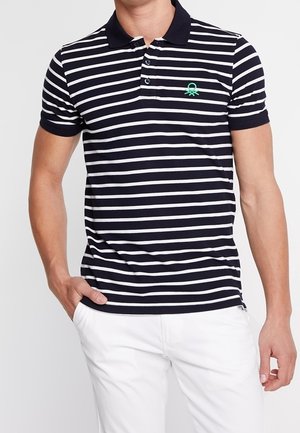 Polo a strisce blu navy e bianche con maniche corte, colletto e logo ricamato verde sul petto. Tessuto in morbido misto cotone.