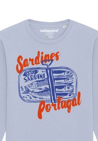 Chemise à manches longues bleu clair avec une illustration bleue d'une boîte de sardines, accompagnée d'un texte rouge indiquant "Sardines Portugal". Design graphique distinctif.