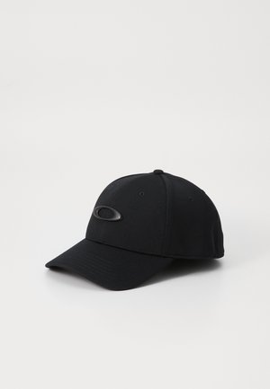 Zwarte honkbalpet met gebogen klep en ovaal logo-embleem aan de voorkant, geplaatst op een witte ondergrond, schuin naar rechts.