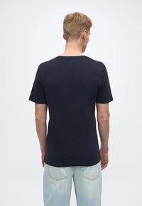 Navy blue short-sleeve T-shirt with a round neckline, made of soft fabric, featuring a simple design and relaxed fit. No visible patterns.