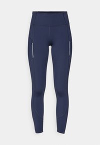 Marineblå leggings laget av stretchstoff, med høy midje og sidelommer med glidelås. Glatt tekstur med sømdetaljer langs bena.