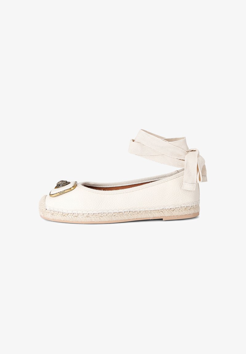 White leather espadrille flat with ankle wrap tie and heart-shaped metal emblem on toe, jute-rope sole, and rubber outsole.