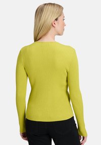 Figurbetontes, geripptes Sweater in leuchtendem Limettengrün. Lange Ärmel, runder Halsausschnitt und strukturierter Stoff. Sichtbare Nähte und nahtloses Rückendesign.