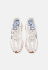 Light gray athletic shoes with suede and mesh upper, white accents, lace-up closure, and a rubber sole with a textured pattern.