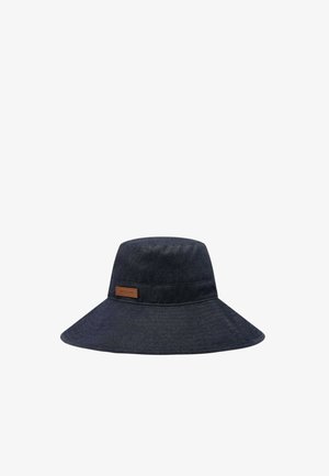Ciemnoniebieski kapelusz typu bucket z szerokim rondem i brązową prostokątną naszywką z logo na opasce, prezentowany na białym tle.