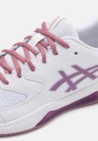 Baltas sportinis batelis su tekstūruota orui laidžia viršutine dalimi, rožinėmis raištelėmis ir levandų spalvos akcentais. Yra Asics logotipas ir kreivasis purpurinis padas.