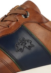 Hnědé kožené tenisky s modrými a zelenými akcenty, se šitým designem, embosovaným logem a kulatým očkem pro tkaničky.