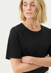 T-shirt nera a maniche corte con scollatura rotonda, realizzata in morbido cotone; presenta un design semplice e una vestibilità comoda.