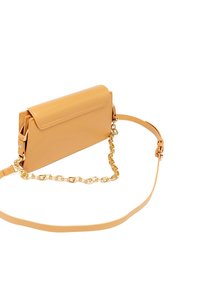 Borsa a tracolla gialla in pelle con chiusura a cappio magnetico, dettagli in catena dorata e tracolla regolabile. Texture liscia e forma rettangolare.