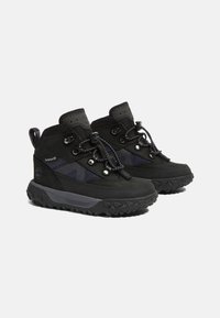 Zwarte wandelschoenen hebben een robuuste uitstraling, een bovenwerk van textiel, een rubberen zool, gestructureerde veters en een gevoerde kraag voor ondersteuning en comfort.