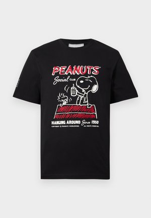 Μαύρο μπλουζάκι με τον Snoopy και τον Woodstock πάνω σε κόκκινο σπιτάκι για σκύλους, κρατώντας ποτά, με το κείμενο «PEANUTS Social Club Hanging Around Since 1950.»