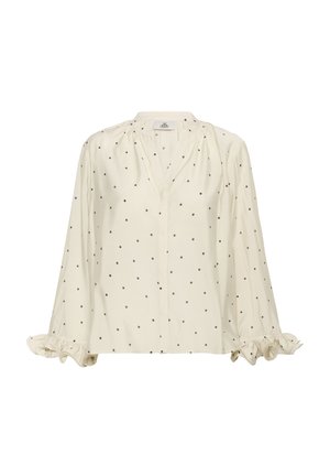 Crème blouse met zwarte stippen, lange mouwen met gerimpelde manchetten en een V-hals. Gemaakt van lichtgewicht stof.