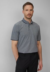Heren polo met korte mouwen in grijze stof met een gestructureerde finish. Voorzien van een marineblauwe kraag en mouwafwerking, met een tweeknoopsluiting.