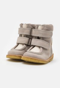 Bottes en cuir gris avec deux sangles velcro réglables, doublure douce, bout rond et semelles en caoutchouc texturé. Nom de la marque "bisgaard" embossé sur les sangles.