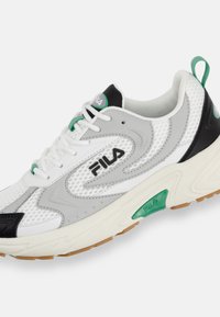 Białe i szare sportowe sneakersy z siateczkowej góry, zielonymi akcentami, czarną osłoną pięty oraz teksturowaną gumową podeszwą. Posiadają sznurowany design.