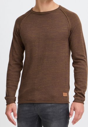 Pull en tricot marron à manches longues, col rond et poignets côtelés. Présente une petite étiquette de marque sur le bas.