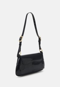 Svart patenterad läderhandväska med gyllene spänne accenter, med en böjd design, justerbar rem och slät, glänsande yta.