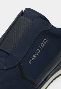 Ναυτικό μπλε παπούτσι με απαλή υφή από σουέτ, ελαστική πλαϊνή επένδυση, διακριτική λεπτομέρεια λογότυπου και καουτσούκ σόλα με αντίθετο trim.