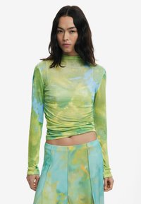 Top aderente a maniche lunghe con motivo tie-dye in tonalità di verde e blu. Presenta un colletto alto e dettagli arricciati lungo i fianchi.