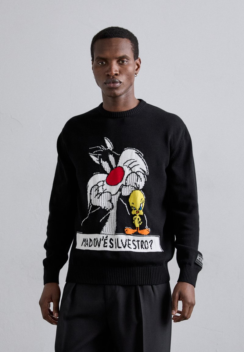 Pull en tricot noir avec un graphique de Sylvester et Tweety Bird. Le texte sous le design dit "Madov'è Silvestro ?" Manches et ourlet à côtes noirs.