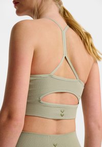 Ljusgrön sport-bh i strukturerad tyg, med en u-cut detalj på baksidan och tunna band som bildar en racerback-design.