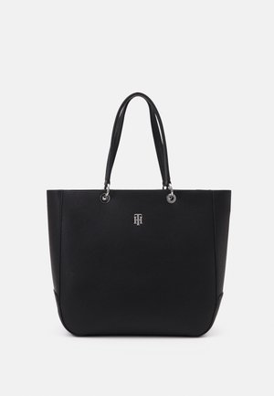 Sort lædertaske med dobbelte håndtag og et lille sølv monogramlogo centreret på forsiden.