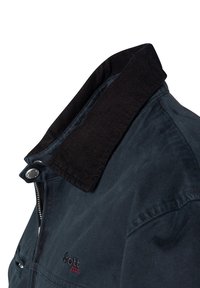 Chaqueta pesada de color azul oscuro con un cuello de pana, cierre de metal y logo bordado. La tela tiene una textura suave y un diseño informal.