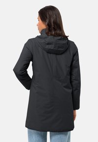 Veste noire imperméable avec capuche, manches longues et longueur mi-cuisse. Présente un tissu lisse et des coutures minimalistes pour un look épuré.