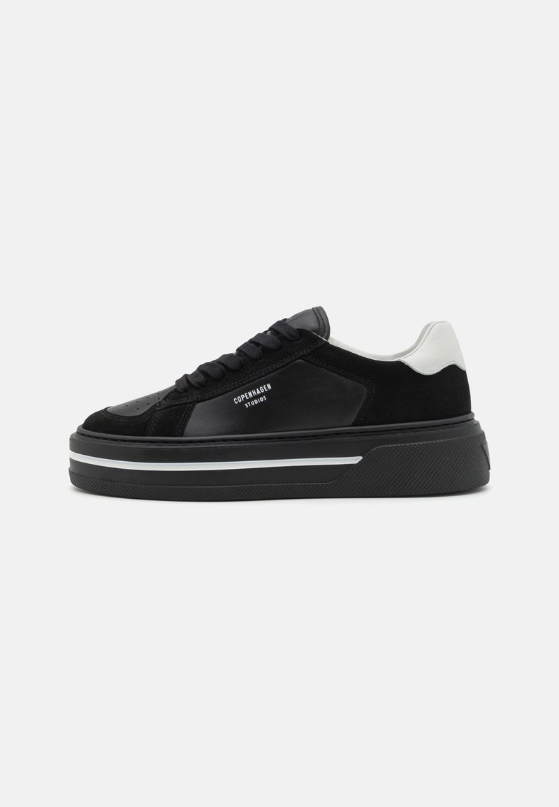 Svarte sneakers laget av lær og semsket skinn, med et elegant design, tykk såle og hvite detaljer på hælen. Merkevaren er synlig.