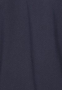 Tecido azul-marinho com um padrão texturizado e perfurado; superfície lisa com um brilho sutil, peso médio, adequado para vestuário desportivo ou roupa casual.